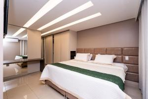 a bedroom with a large bed with white sheets at Luxurious 2-Bedroom Duplex with Gourmet Balcony in Goiânia +116 photos