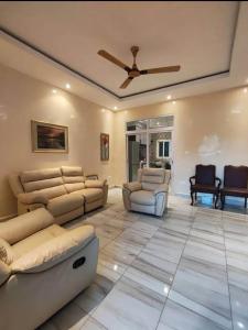 a living room with couches and a ceiling fan at Stepping Stone Apartments in Bijilo