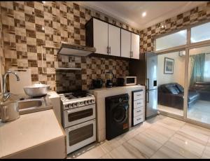 a kitchen with a stove and a sink at Stepping Stone Apartments in Bijilo