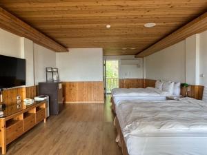 a room with two beds and a flat screen tv at Cingjing Brilliant Twins of Seattle in Ren'ai