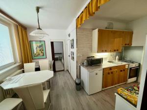 a kitchen with a white refrigerator and a table at Apartmán BlueA in Jihlava