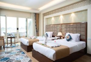 a hotel room with two beds and a table at Nile Transport Hotel in Cairo