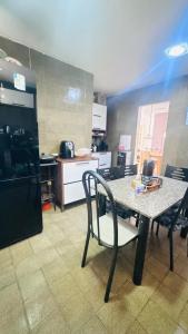 a table and a chair in a kitchen at Casa com piscina in Paulista