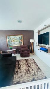 a living room with a couch and a flat screen tv at Casa com piscina in Paulista