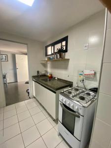 a white kitchen with a stove and a sink at APARTAMENTO EM NATAL III in Natal