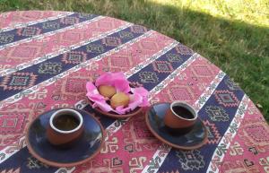 two cups of coffee and a bowl of flowers on a table at Saro B&B in Tatev in Tandzatapʼ