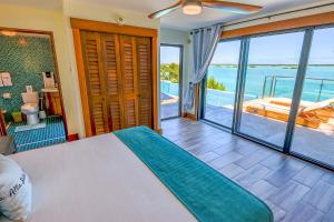 a bedroom with a bed and a view of the ocean at Alta Bella Villa 8 Bdr Oceanfront Nordic Spa in Providenciales +42 photos