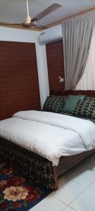 two twin beds in a room with a window at Sunset Banana Beach Resort in Prampram