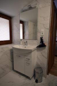 a white bathroom with a sink and a mirror at Apartament Pod Jasieniem Jurgów in Jurgów +5 photos