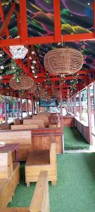a pavilion with benches and baskets and red beams at Sunset Banana Beach Resort in Prampram