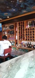 a man sitting at a bar in a restaurant at Sunset Banana Beach Resort in Prampram +11 photos