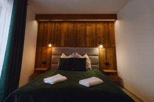 a bedroom with a bed with two towels on it at Apartament Pod Jasieniem Jurgów in Jurgów