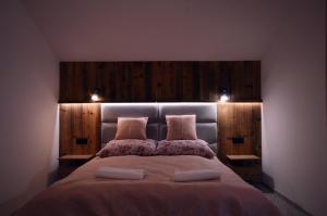 a bedroom with a large bed with two pillows at Apartament Pod Jasieniem Jurgów in Jurgów