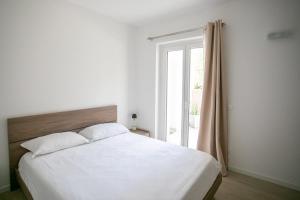 a bedroom with a large white bed and a window at Dal Ross 2 in Riva di Solto