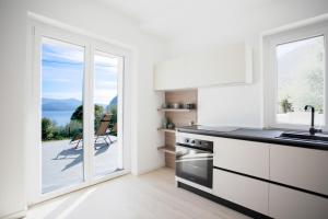 a kitchen with a large glass door leading to a patio at Dal Ross 2 in Riva di Solto