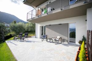 a patio with chairs and a table in front of a house at Dal Ross 2 in Riva di Solto