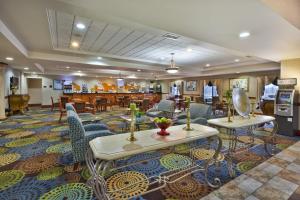 a hotel lobby with tables and chairs and a restaurant at Holiday Inn Express Hotel & Suites - Belleville Area by IHG in Belleville