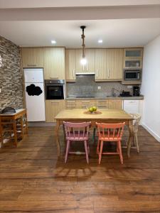 a kitchen with a wooden table and two chairs at Valdefornos in Pontevedra