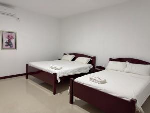 two beds sitting next to each other in a room at Day And Night Hotel Belmopan in Belmopan