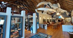 a large room with a store with tables and chairs at Tide's Edge in Gansbaai