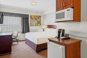 ein Hotelzimmer mit Bett und Küche in der Unterkunft Elk Island Studios - Lamont in Lamont