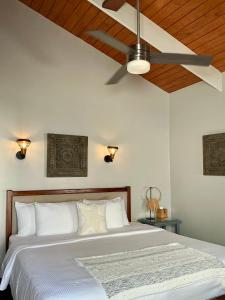 a bedroom with a bed with a ceiling fan at Mata Rocks Resort in San Pedro +55 photos
