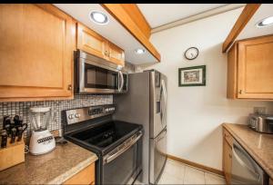 a kitchen with a stainless steel refrigerator and microwave at Poipu Beach Condo with AC and Pool in Koloa