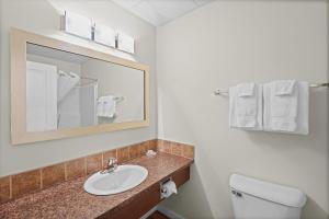 ein Badezimmer mit Waschbecken, Toilette und Spiegel in der Unterkunft Elk Island Studios - Lamont in Lamont + 21 Fotos