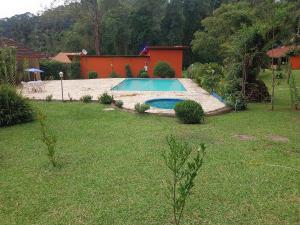 a swimming pool in a yard with a house at Chalé Refúgio na Alameda Maringá MG in Bocaina de Minas +7 photos