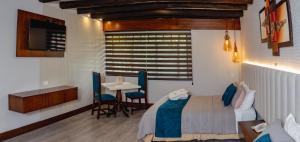 a bedroom with a bed and a table with chairs at Hosteria Duran in Cuenca