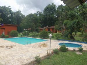 a swimming pool in the yard of a house at Chalé Refúgio na Alameda Maringá MG in Bocaina de Minas