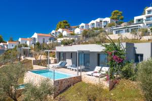 eine Villa mit Swimmingpool auf einem Hügel mit Häusern in der Unterkunft Adrina Grand Hotel in Panormos Skopelos