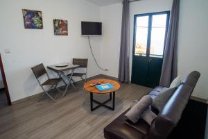 ein Wohnzimmer mit Sofa und Tisch in der Unterkunft Sunset Star with Sea View in Calheta