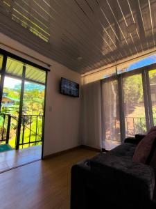 a living room with a couch and large windows at Alma Luna Chalet in Vergara