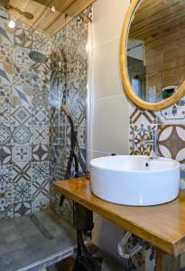 a bathroom with a sink and a mirror on a table at Villa Haris in Sarti