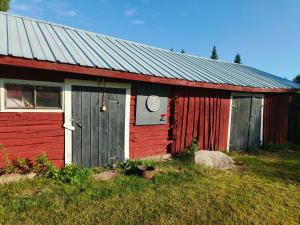 a red and white building with a door at Northern Cabin in Havukkavaara +14 photos