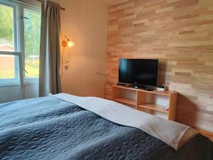 a bedroom with a bed and a flat screen tv at Northern Cabin in Havukkavaara
