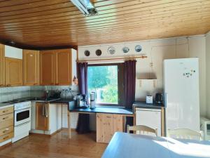 a kitchen with wooden cabinets and a window at Northern Cabin in Havukkavaara