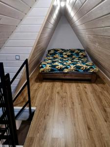 a bedroom with a bed and a wooden floor at Domki pod Derkaczem in Radków