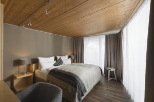 a hotel room with a bed and a chair at Skihotel Galzig B&B in Sankt Anton am Arlberg