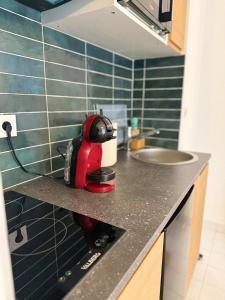 a red appliance sitting on a counter in a kitchen at Le Matin bohème Paris- Orly- By Chozen in Épinay-sur-Orge +3 photos
