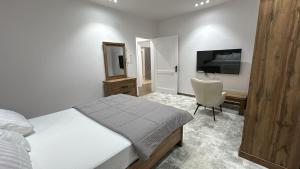 a bedroom with a bed and a desk and a television at ملاذ العلا in Al-ʿUla