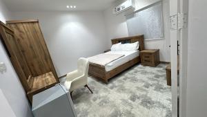 a bedroom with a bed and a chair in it at ملاذ العلا in Al-ʿUla
