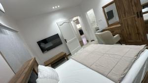 a bedroom with a bed and a tv and a chair at ملاذ العلا in Al-ʿUla