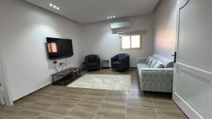 a living room with a couch and a tv at ملاذ العلا in Al-ʿUla