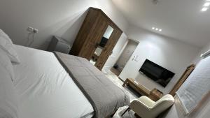 a bedroom with a large bed and a tv at ملاذ العلا in Al-ʿUla +15 photos