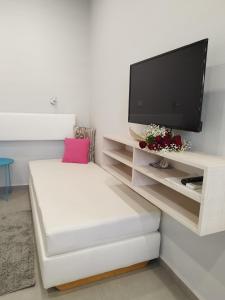 a living room with a white couch and a flat screen tv at Villa Katerina in Chania
