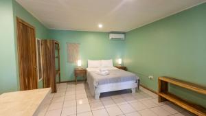 a bedroom with a bed in a green wall at GALA Santa Teresa Studios - Walk to Beach & Surf in Santa Teresa Beach