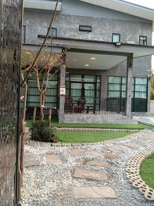 a house with a stone walkway and a patio at Loft Life Pool villa in Ban Huai Yai
