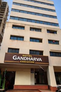 a tall building with a sign in front of it at Hotel Gandharva Executive in Pune